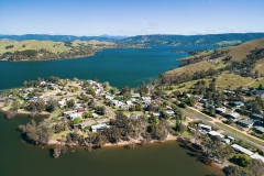 An aerial view of residential housing nestled amongst gumtrees and hills on the edge of Lake Eildon. An aerial view of residential housing nestled amongst gumtrees and hills on the edge of Lake Eildon.